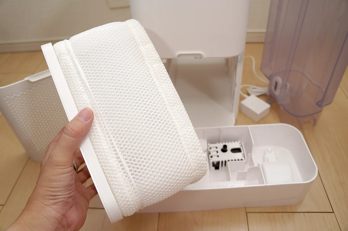 トレイから加湿フィルターを持ち上げて取り出す様子